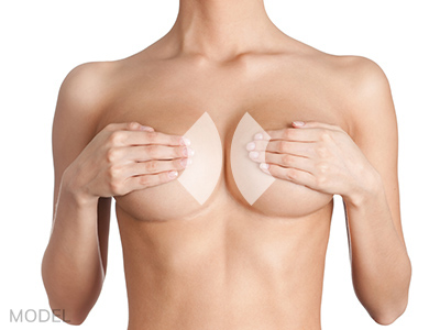 Model of woman covering breasts