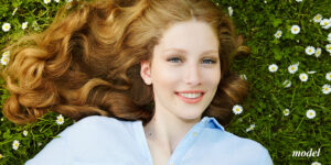 Close up of female face laying on grass with flowers surrounding | lavinia k chong m D