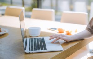 Photo of model sitting at computer.