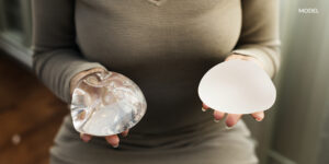 Female Hands Holding Out Two Different Types of Breast Implants