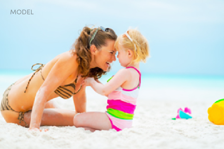 Woman with child playing on beach | lavinia k chong m D