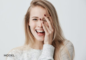 Laughing female covering half her face with hand