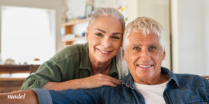 Older couple sitting at home smiling